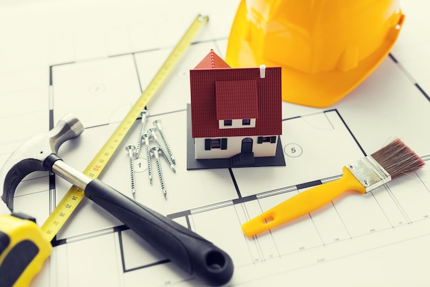 architettura, costruzione, immobiliare e concetto di casa - primo piano di modello di casa vivente su progetto con strumenti di riparazione