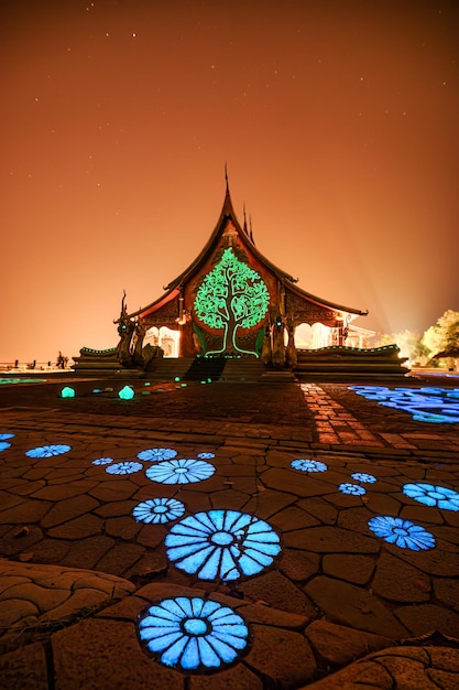 Architettura del tempio della chiesa con albero della bodhi incandescente e pittura di loto fluorescente sul pavimento al Wat Sirindhorn Wararam o Wat Phu Prao