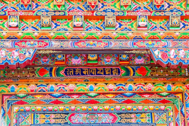 Architettura unica nella parete di casa in stile tibetano sul muro rosso