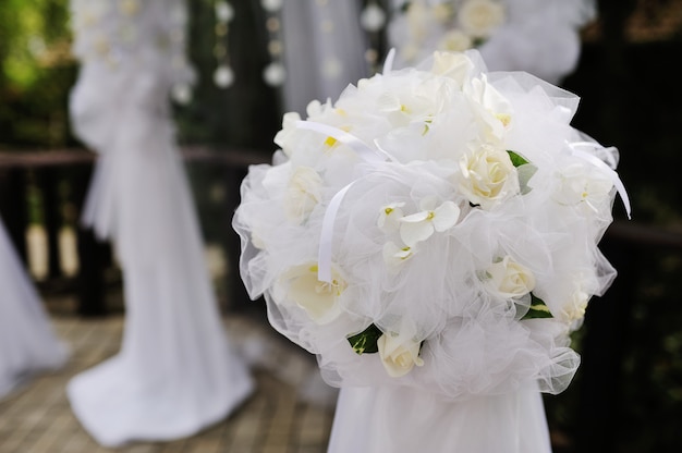 Arco da sposa bianco decorato con fiori bianchi e perle