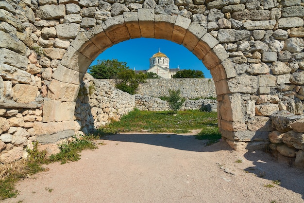 Arco di pietra nell'antica città sullo sfondo del cielo e della cattedrale