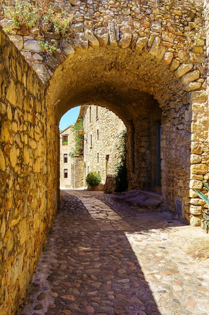 Arco in pietra in un vicolo con case in pietra nella città medievale di Pals Girona