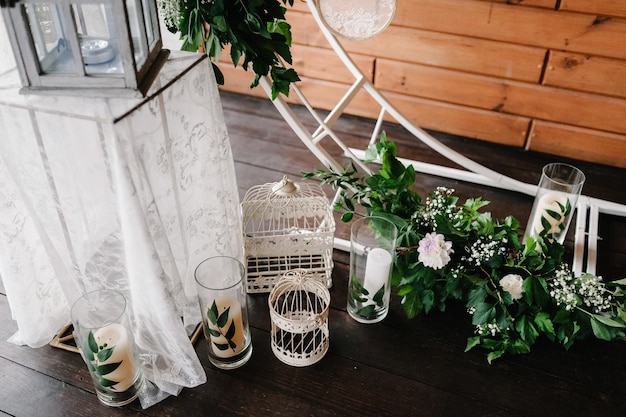 Arco per la cerimonia di nozze è decorato con fiori bianchi e verdi verdi Candele sullo sfondo della parete in legno Decorazione di nozze in stile boho