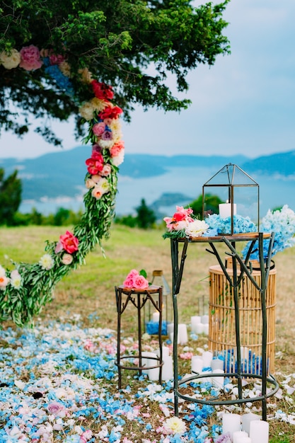 Arco rotondo nuziale di fiori e rami di ulivo appesi al