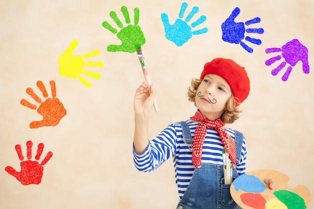 Arcobaleno di pittura bambino felice a casa.