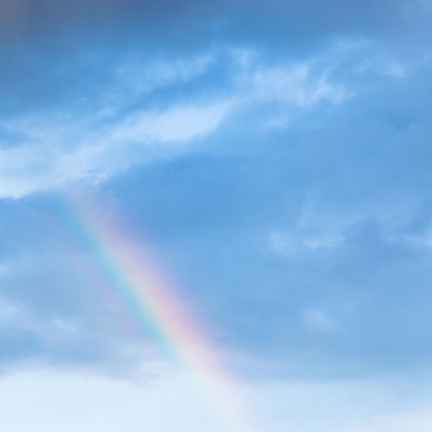 Arcobaleno in nuvole di pioggia nel cielo blu della sera