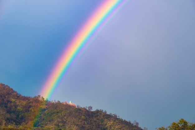 Arcobaleno luminoso colorato nel cielo. Tempio sulla collina.