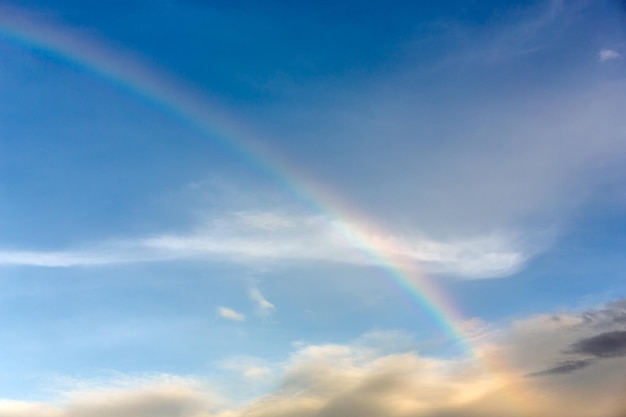 Arcobaleno nel cielo blu con nuvola al tramonto