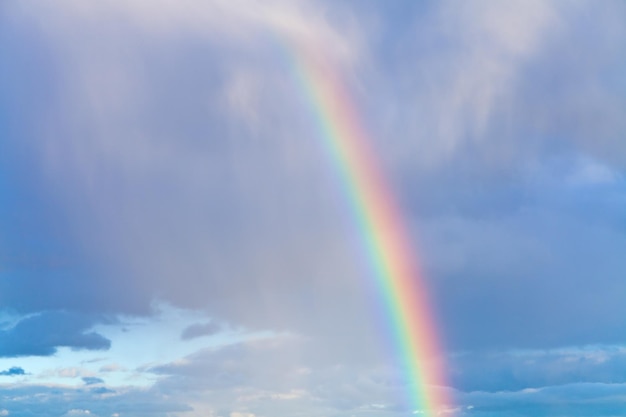 Arcobaleno nel cielo nuvoloso blu