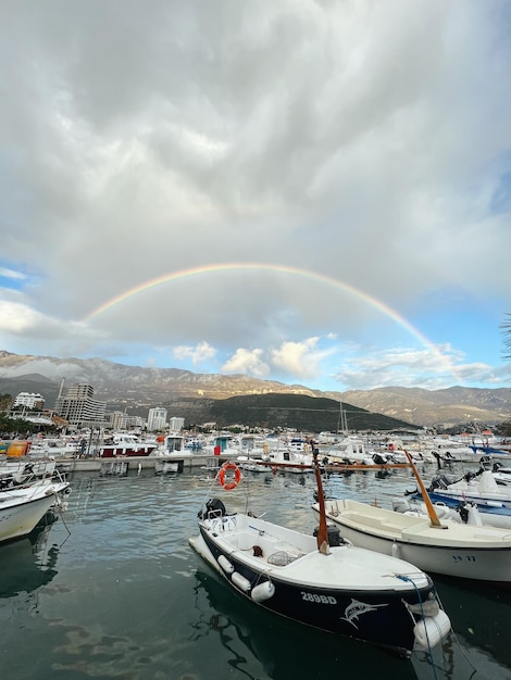 Arcobaleno nel cielo sopra le montagne sopra il porto turistico