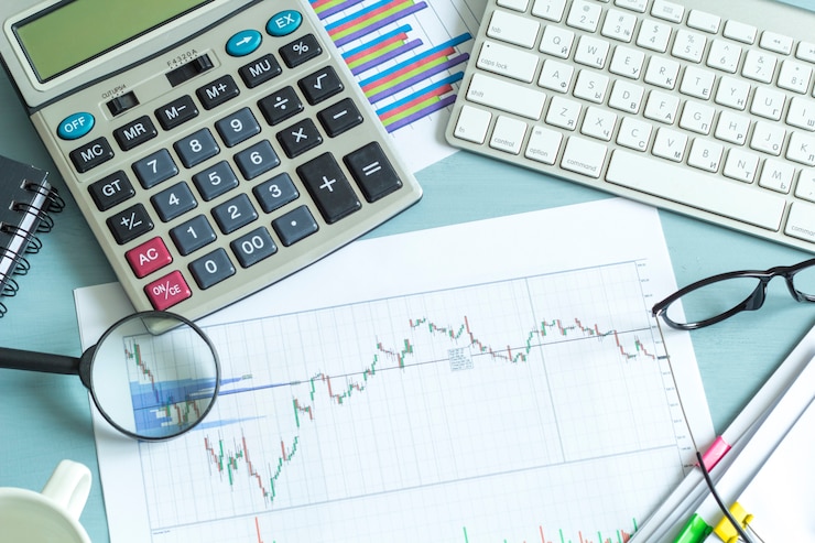 Foto area di lavoro. calcolatrice, grafico, occhiali, tastiera - concetto di relazione finanziaria, contabilità.