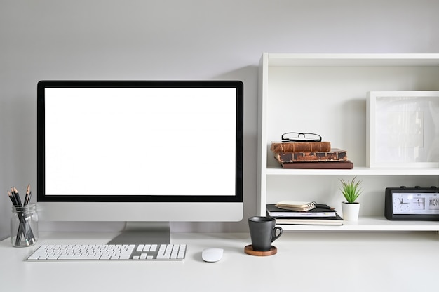 Area di lavoro con iMac Computer sulla scrivania e libri, portafoto e libri sugli scaffali.