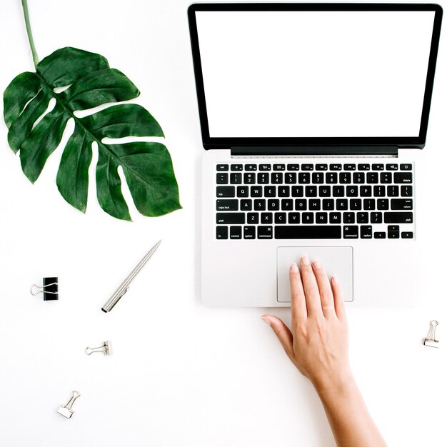 Area di lavoro con la donna che lavora al computer portatile con lo schermo vuoto