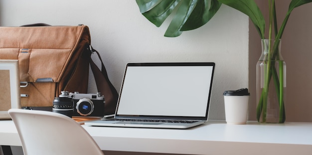 Area di lavoro confortevole con computer portatile a schermo vuoto con busta postale