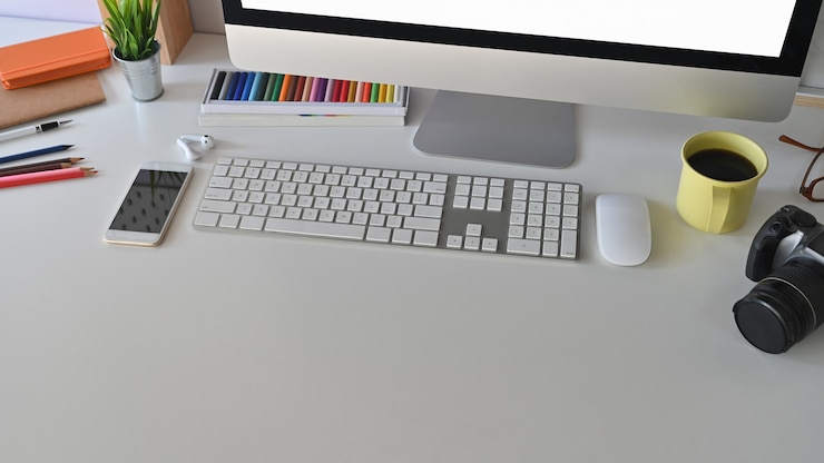 Foto area di lavoro creativa, tazza di caffè e attrezzature sulla scrivania.