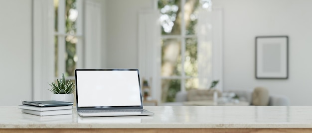 Area di lavoro domestica con mockup portatile su tavolo in marmo bianco in un soggiorno luminoso e accogliente minimo