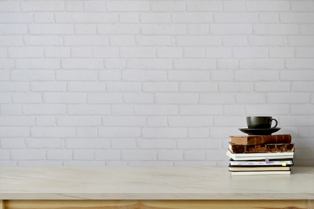 Area di lavoro e copia spazio con libri, tazza da caffè sul tavolo di marmo.