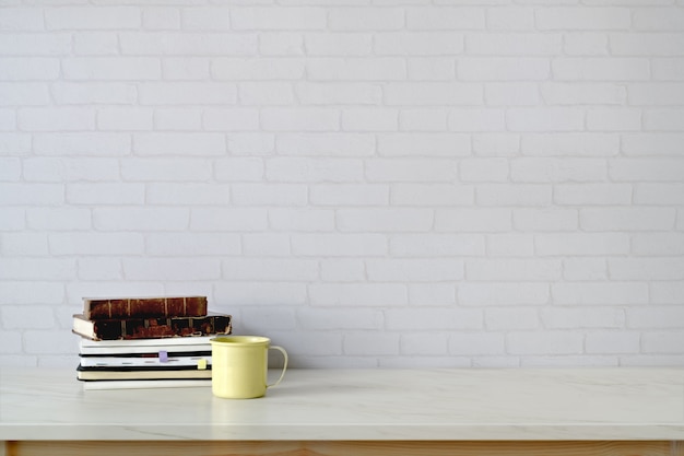 Area di lavoro e copia spazio con libri, tazza da caffè sul tavolo di marmo.