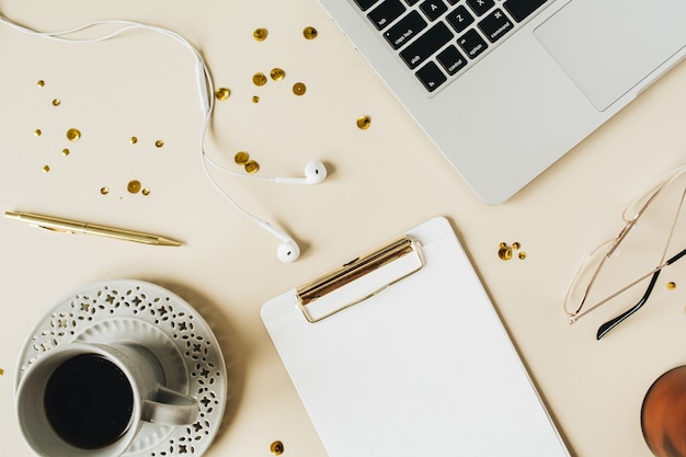 Area di lavoro scrivania da casa con appunti, laptop, caffè sul beige