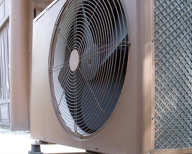 Aria condizionata (HVAC) sul tetto di un edificio industriale con cielo blu e nuvole.