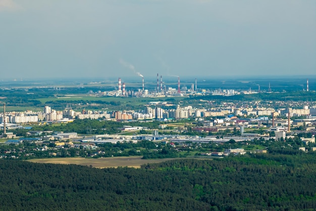 Ariel vista panoramica della città e dei grattacieli con un'enorme fabbrica con camini fumanti sullo sfondo