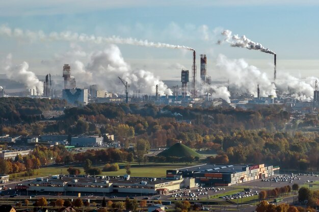 Ariel vista panoramica della città e dei grattacieli con un'enorme fabbrica con camini fumanti sullo sfondo