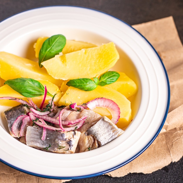 Aringhe e patate secondo piatto di pesce marinato cipolla fresca pasto pronto spuntino in tavola