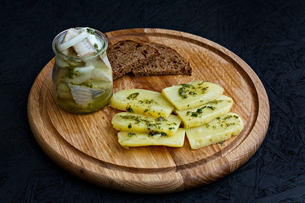 Aringhe salate in un vaso con patate bollite e salsa verde.