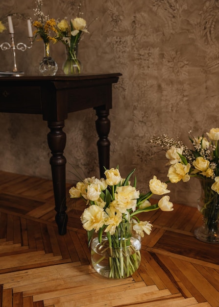 Armadio interno con tavolo antico e vaso con bouquet di tulipani gialli