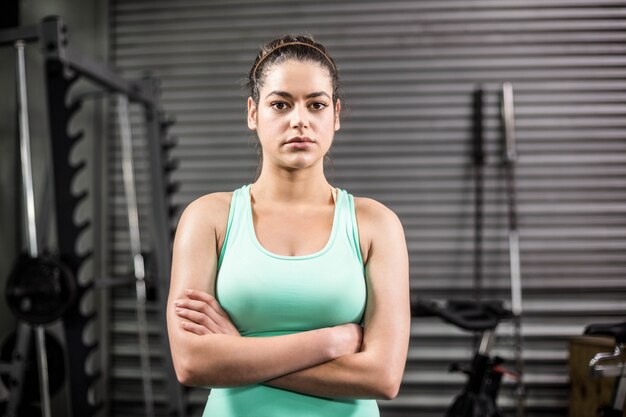 Armi attraversanti infelici della donna atletica alla palestra