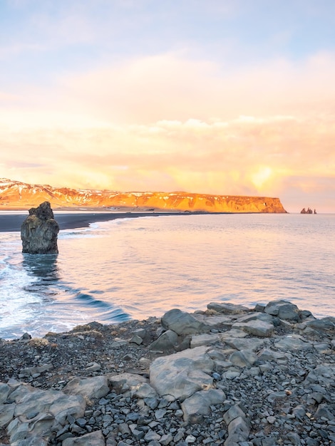 Arnardrangur noto come Eagle rock sulla costa vicino all'arco di Dyrholaey con onde pesanti a sud dell'Islanda