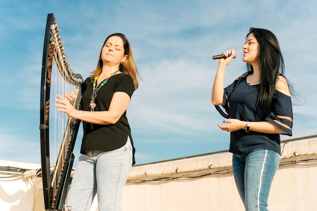 Arpista e cantante che fanno uno spettacolo musicale sul tetto