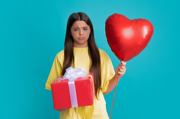 Arrabbiato ragazza adolescente sconvolto e infelice emozione negativa Adolescente bambino con confezione regalo Presente per le vacanze Amore palloncino cuore di San Valentino