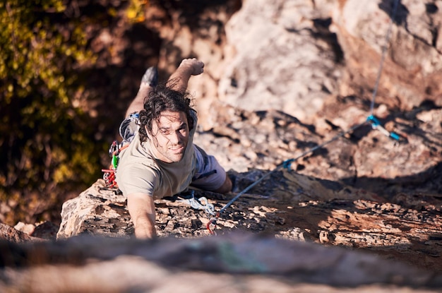 Arrampicata su roccia fitness e montagne con l'uomo nella natura per lo sport esplorare e avventura Allenarsi e viaggiare con l'allenamento della persona sulla scogliera per la sfida e le prestazioni della corda