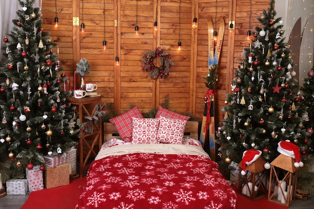 Arredamento accogliente all'interno della camera di Capodanno Letto di regali di ghirlande di alberi di Natale