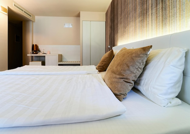 Arredamento camera da letto e arredamento di design moderno e pittura murale. Camera in appartamento con letto e cuscini bianchi e coperta e arredamento d'arte. Stile italiano nello spazio dell'hotel