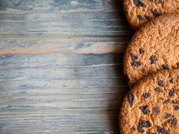 Arredamento di roba dolce cibo su fondo di legno grezzo. biscotti con gocce di cioccolato sulla superficie in legno con spazio libero.