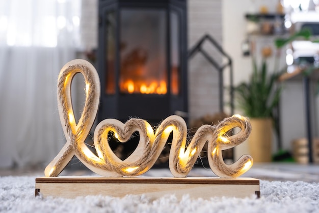 Arredamento di San Valentino vicino al caminetto con fuoco e legna da ardere Accogliente focolare domestico all'interno con piani in vaso San Valentino nel nido d'amore della famiglia