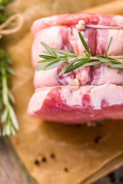 Arrosto di leone di maiale biologico con rosmarino su tavola da fattoria in legno.