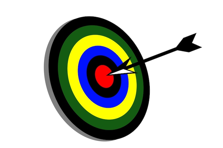 Photo arrow hitting center of target on a white background