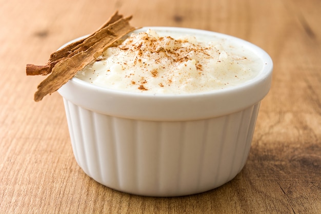 Arroz con leche o budino di riso con cannella sulla tavola di legno