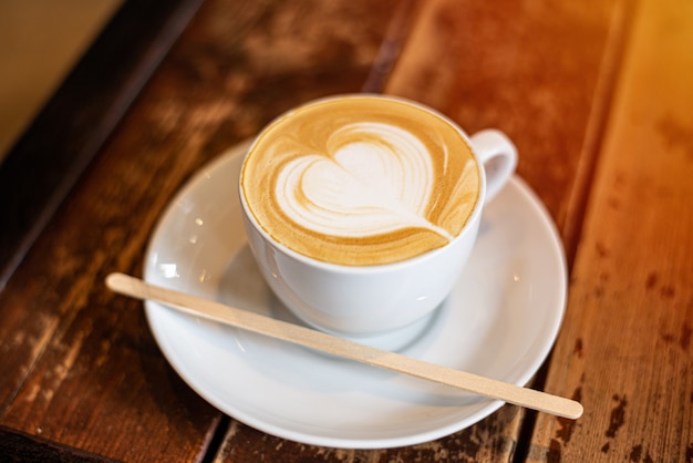 Arte del latte della tazza di caffè su fondo di legno