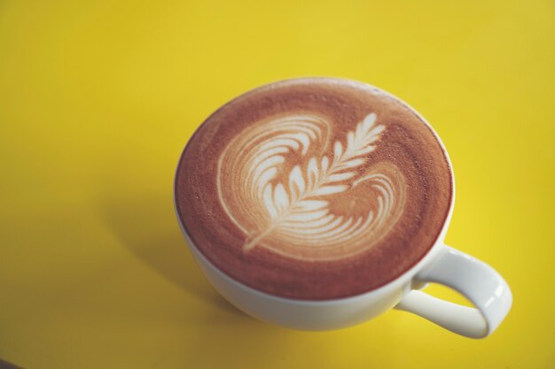 Arte del latte sul tavolo del caffè giallo, caffè caffè