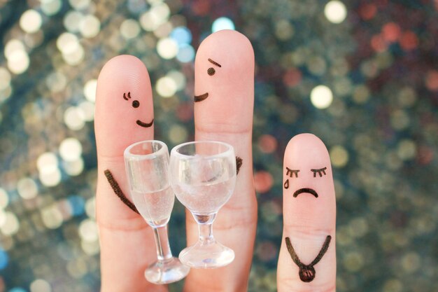 Arte delle dita di coppia felice. L'uomo e la donna bevono bevande alcoliche. Il bambino è arrabbiato e risentito.