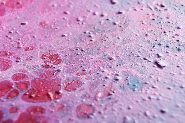 Arte fluida Tratti in rilievo crateri e gocce di vernice rosa Sfondo o texture effetto marmo Messa a fuoco selettiva