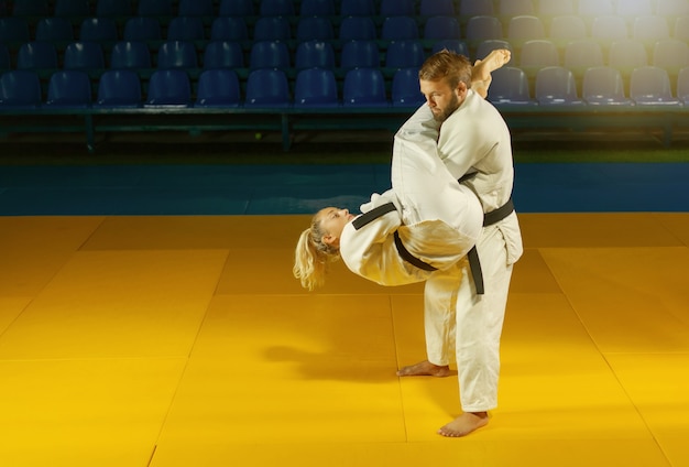 Arti marziali. Portatori risparmiatori. Sport uomo e donna in kimono bianco treno judo getta e cattura nel palazzetto dello sport