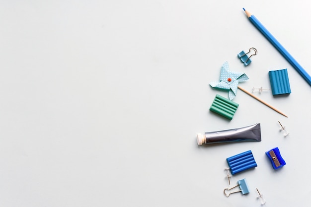 Articoli di cancelleria su sfondo blu. Forbici, matite e plastilina, oggetti per la creatività. Copia spazio
