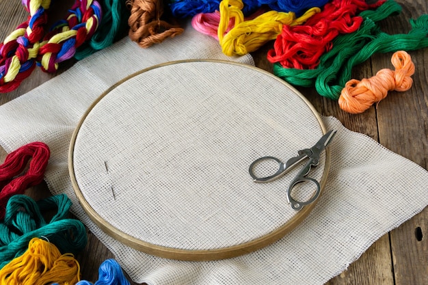 Articoli per ricamo. Hoop, fili colorati e tela su legno vecchio.
