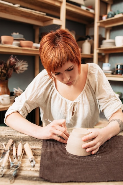 Artigiana che decora la ciotola di ceramica