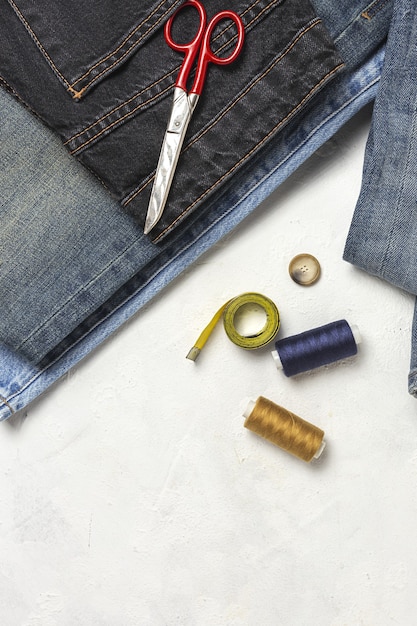 Artigianato, riparazione abbigliamento. Accessori per cucire jeans strappati dall'alto. Lay piatto